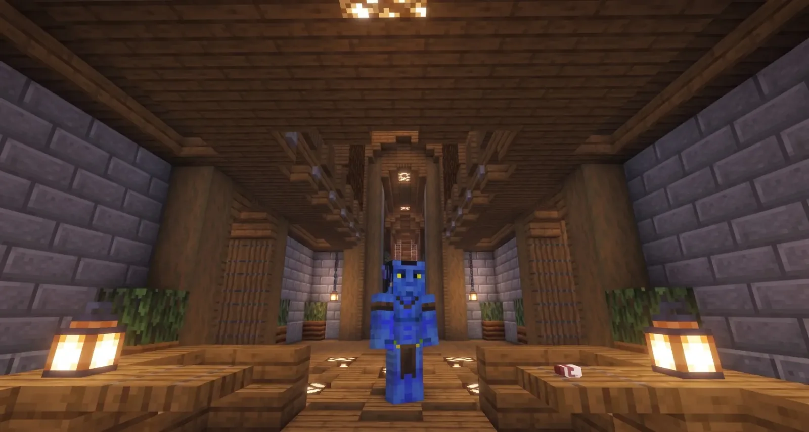 Titi, avec une peau bleue, dans une grande salle en bois éclairée de lanternes